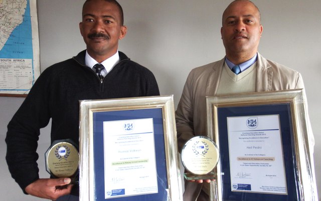 Vlnr is Tommy Volkwyn (hoof) en Neil Pedro (adjunkhoof) van Gansbaai Primêr met hul trofeë en geraamde sertifikate 